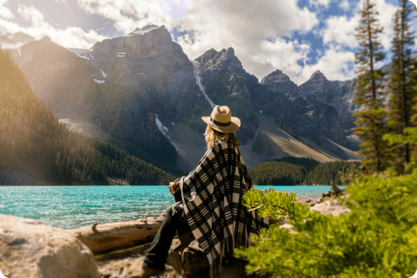 A local guide sitting by a scenic mountain lake